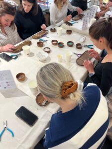 Participants concentrés autour d’une table lors d’un atelier de création de bijoux à Toulouse.