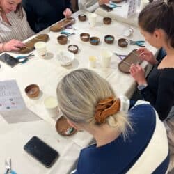 Participants concentrés autour d’une table lors d’un atelier de création de bijoux à Toulouse.
