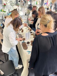 Groupe de femmes en train de créer leurs bijoux dans une boutique décorée à Toulouse.